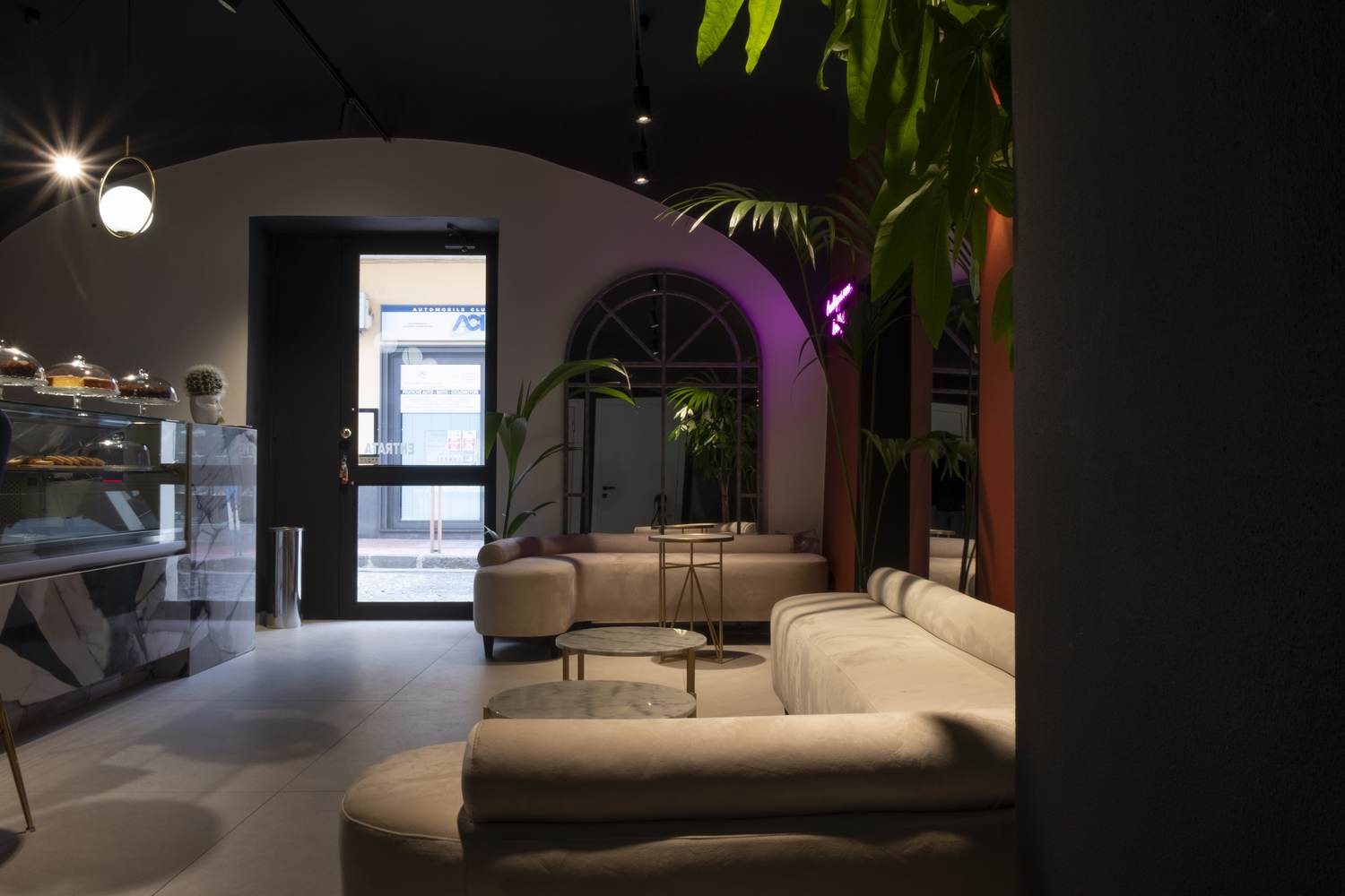 Zona lounge con divani e specchi ad arco