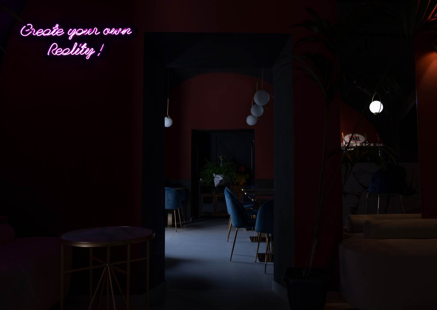 Neon 'Create your own Reality' su parete rossa